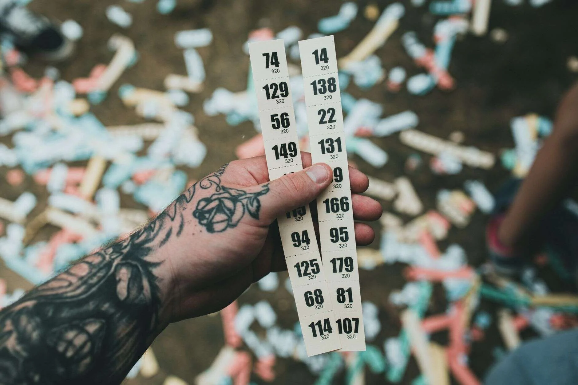 Mano sosteniendo boletos numerados entre confeti