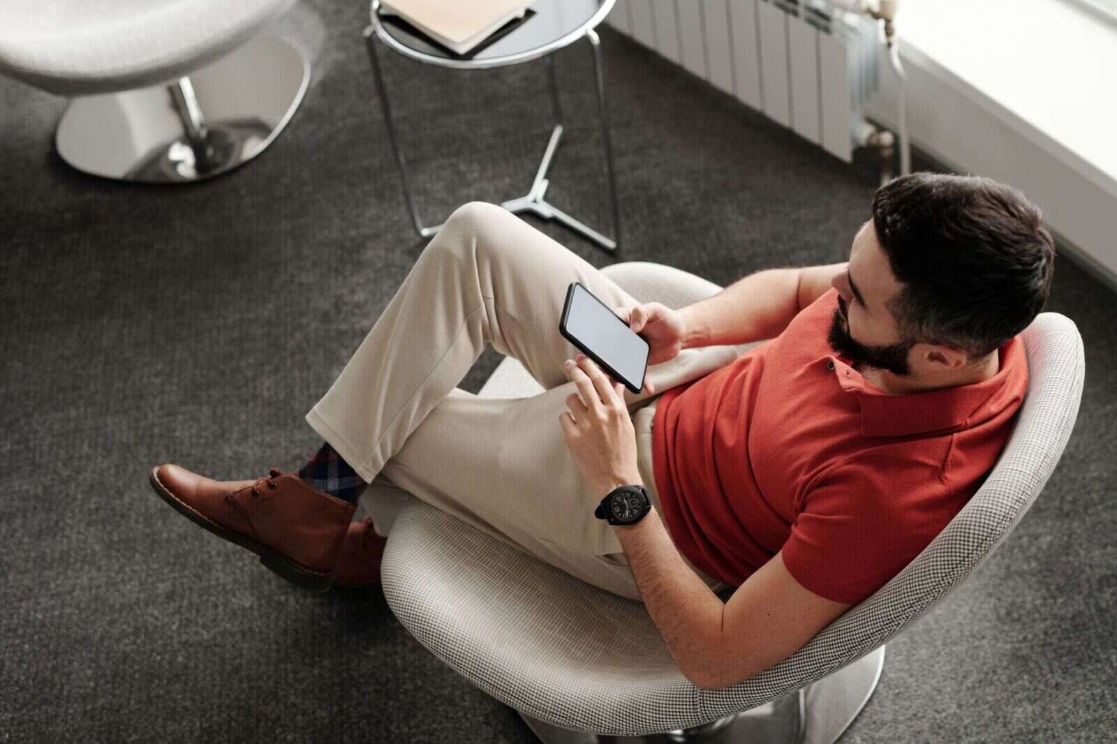 Hombre consultando el móvil sentado en casa