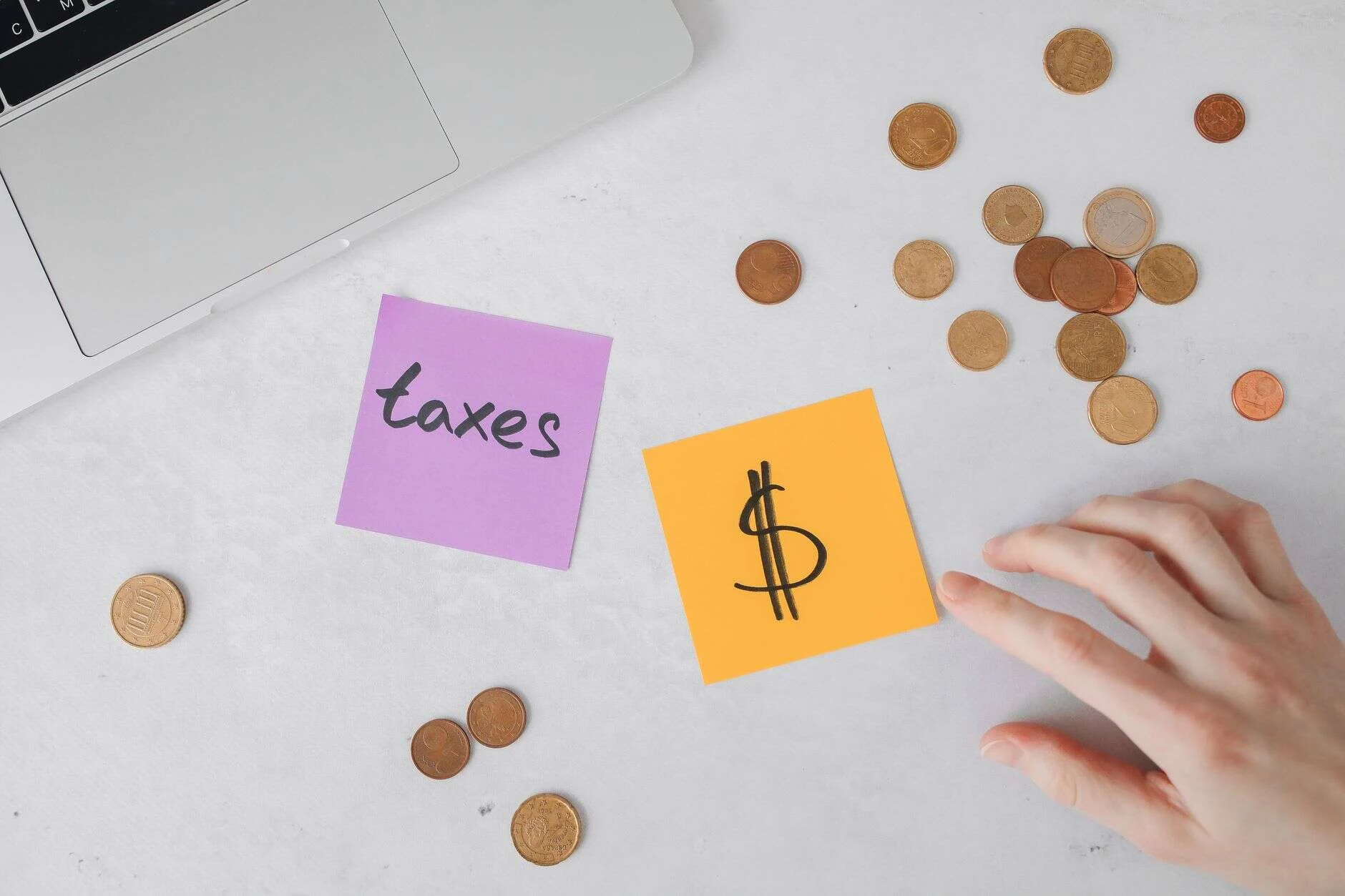Monedas y notas con símbolos de impuestos sobre una mesa