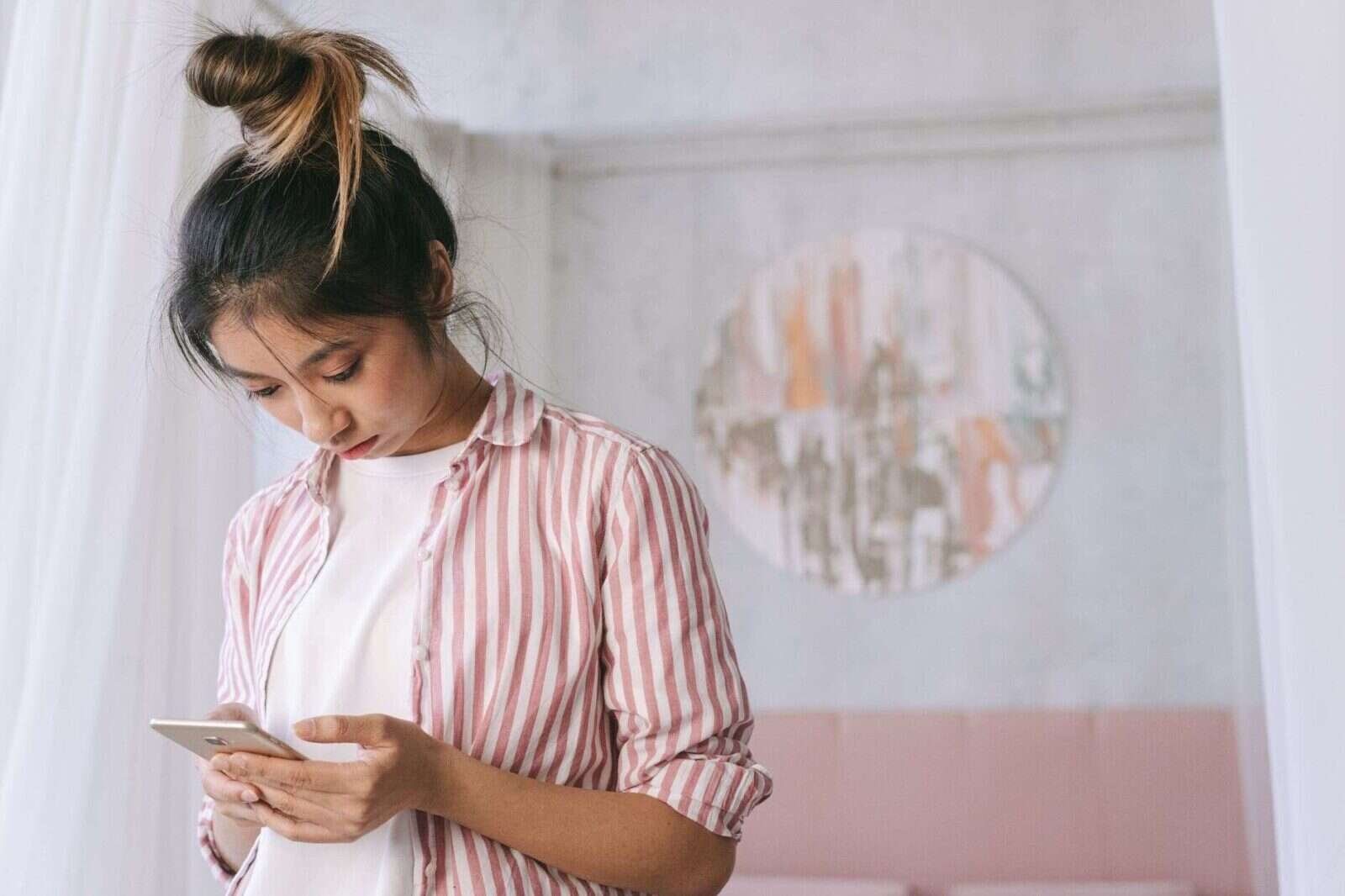 Mujer joven consultando el móvil en casa