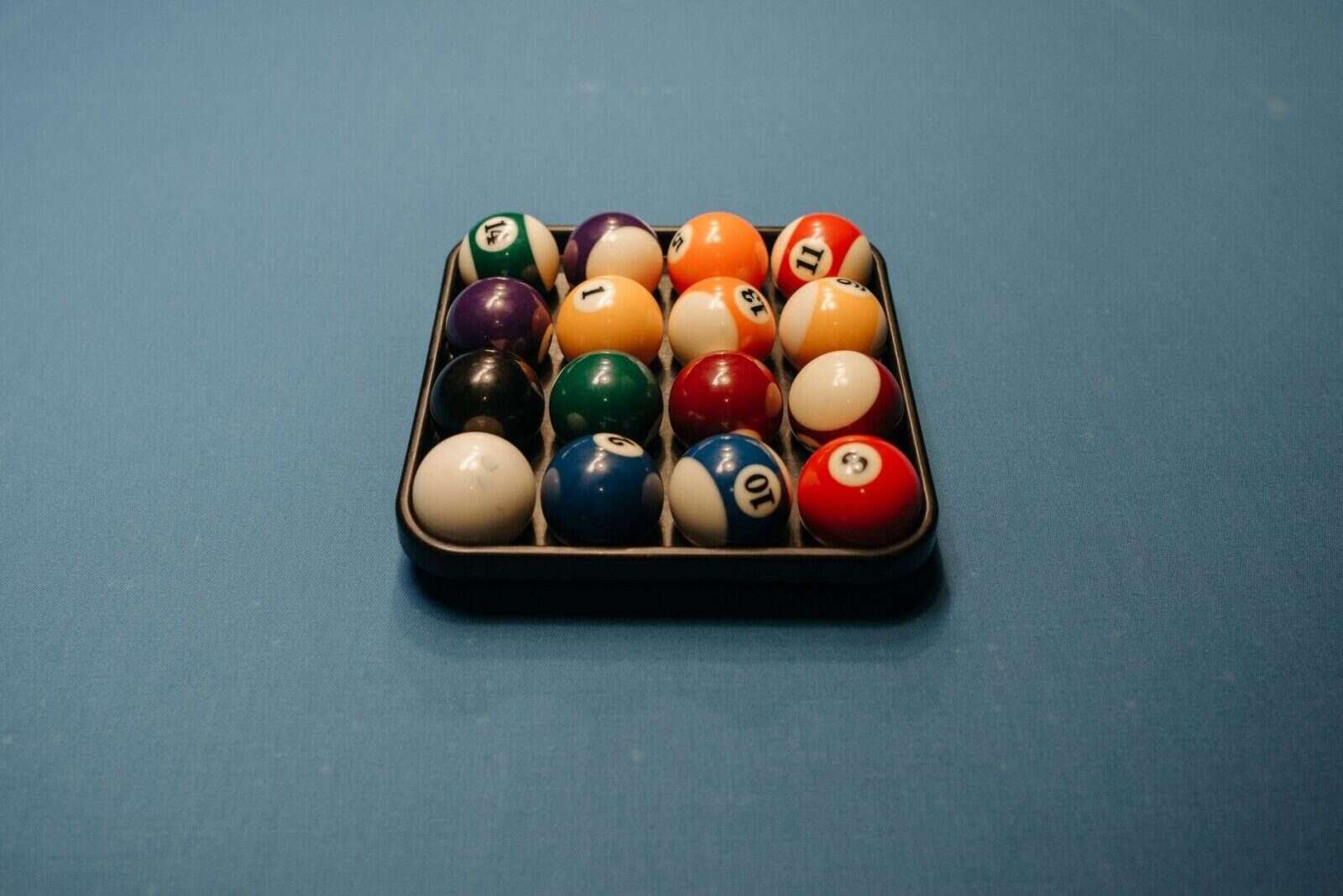 Bolas de colores numeradas dispuestas sobre una mesa azul